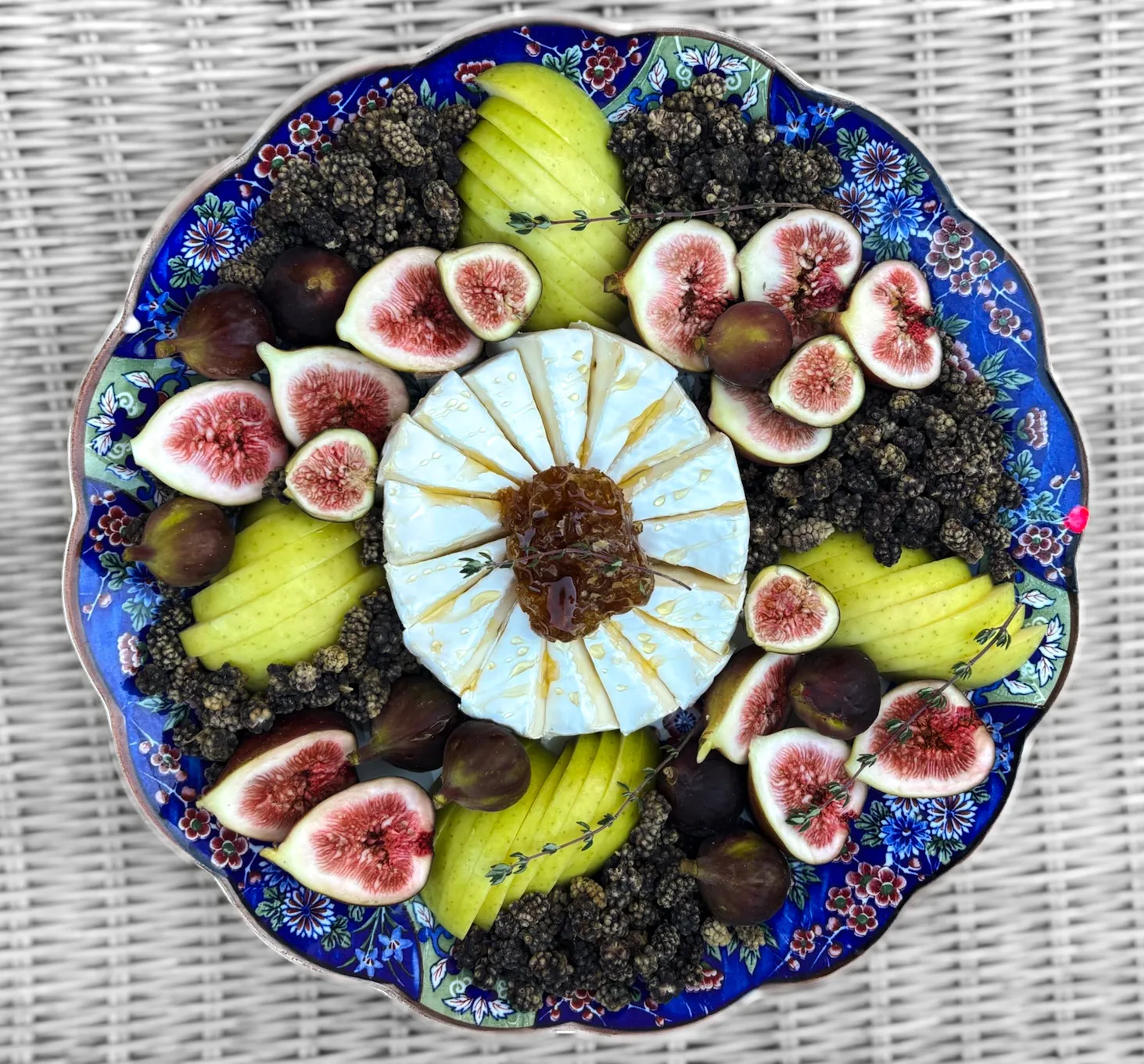 A beautiful charcuterie board with a variety of cheeses, fruits, and nuts.